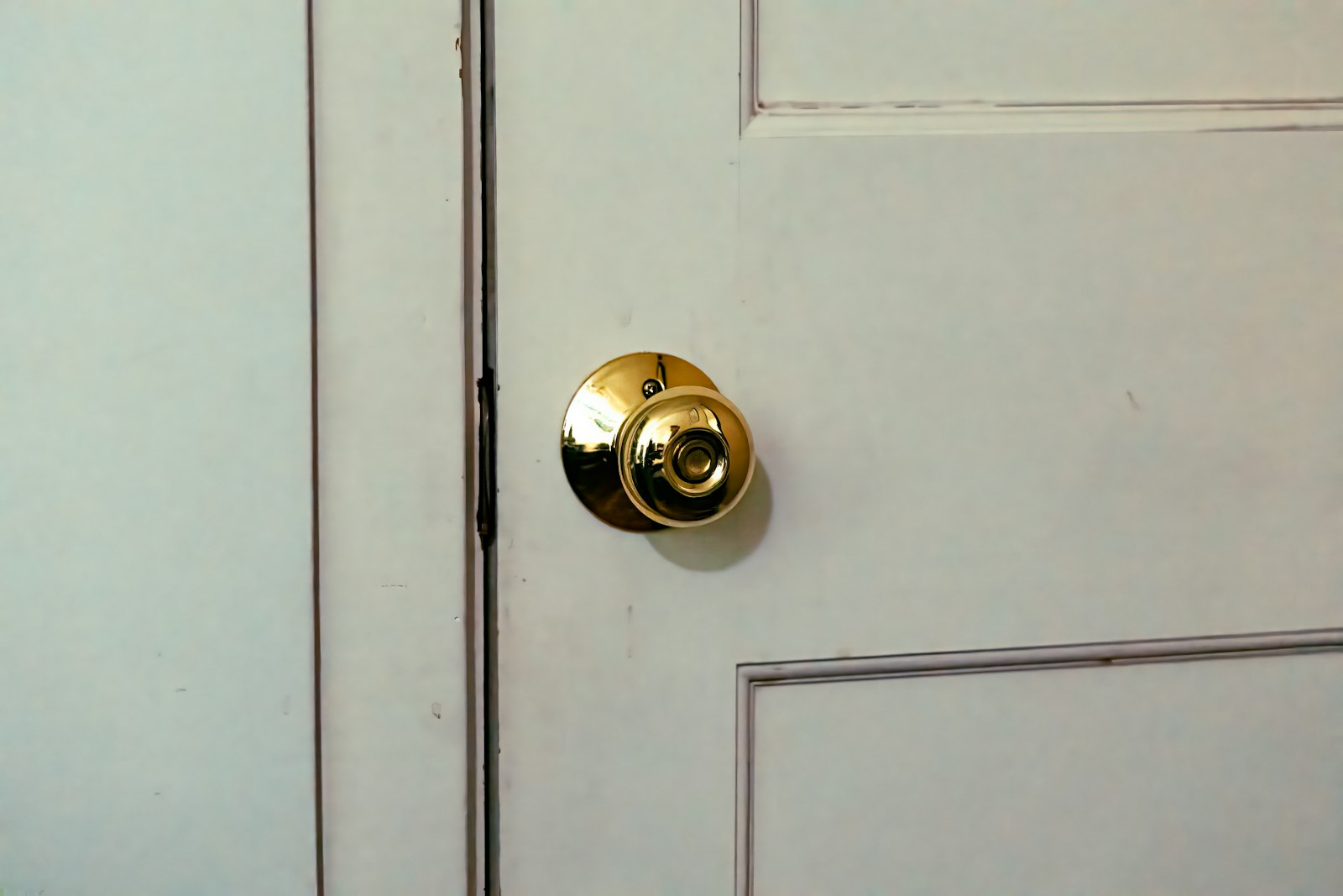 New brass doorknob installed on a white door